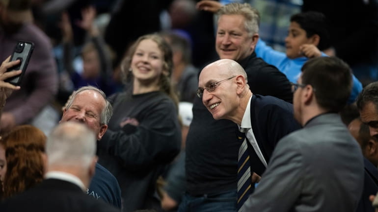 NBA Commissioner Adam Silver, center, takes photographs with fans in...