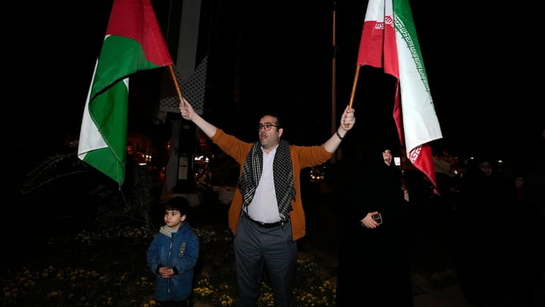 A demonstrator waves Iranian and Palestinian flags during an anti-Israeli...