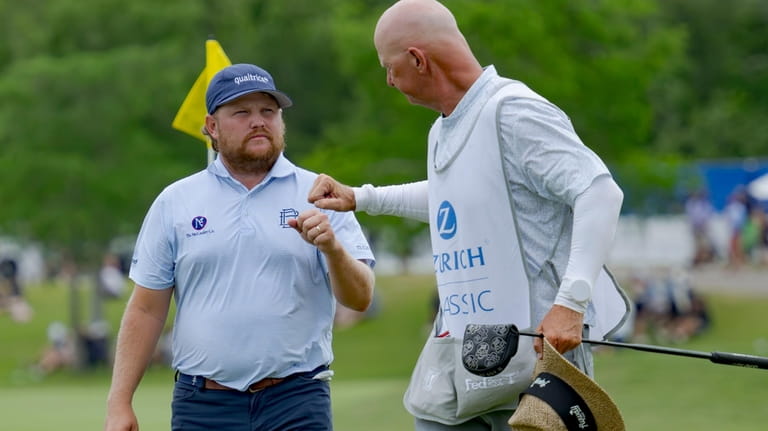 Zac Blair, left, fist-bumps the caddie of Patrick Fishburn after...
