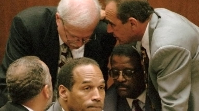 O.J. Simpson is surrounded by his defenseattorneys, clockwise from left,...