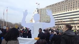 An effigy implicitly conveys the slogan "Hands up, don't shoot"...