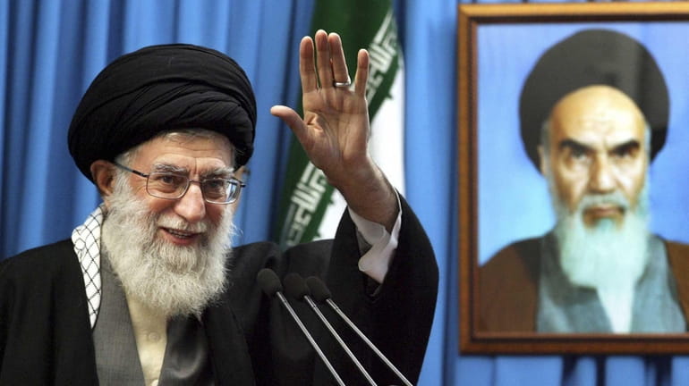 Iranian supreme leader Ayatollah Ali Khamenei waves to the worshippers,...