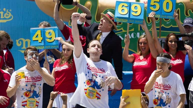 Joey Chestnut, center, wins the Nathan's Famous Fourth of July...