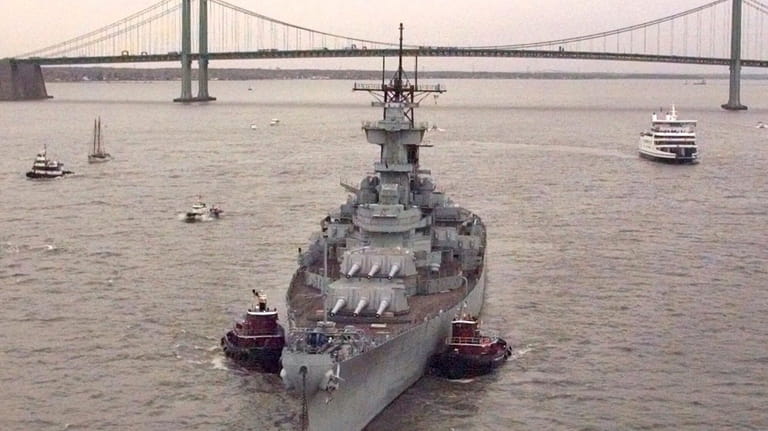 The Battleship USS New Jersey is towed past the Delaware...