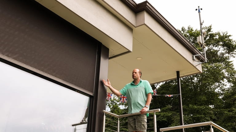 Rob Steels points out the external automated solar blinds on his green home...