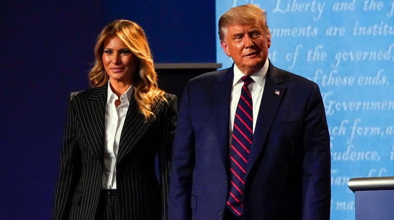 First lady Melania Trump and President Donald Trump stand on stage...