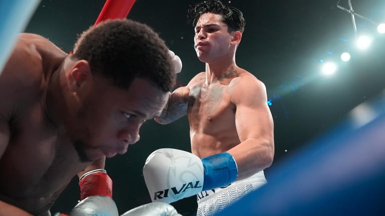 Ryan Garcia, right, punches Devin Haney during the first round...