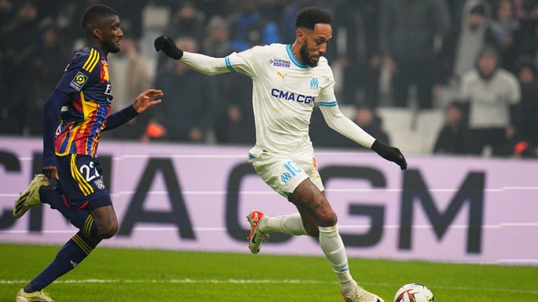 Lyon's Clinton Mata, left, challenges as Marseille's Pierre-Emerick Aubameyang passes...