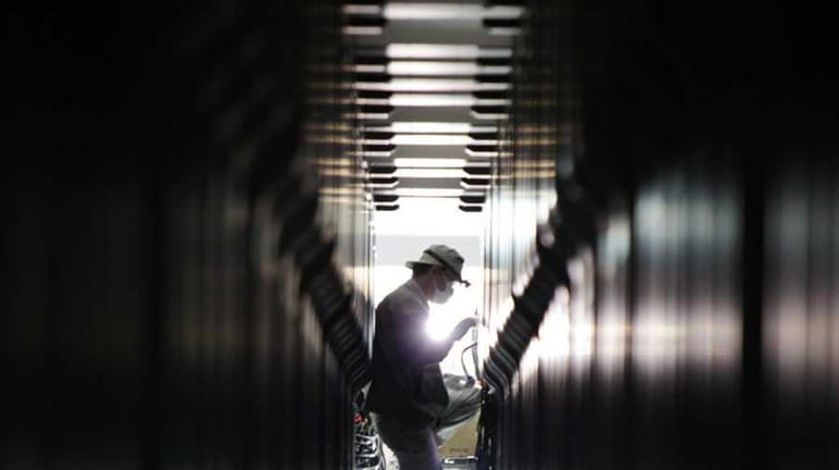 Workers install the "K Computer" supercomputer at Japan's Riken Institute...