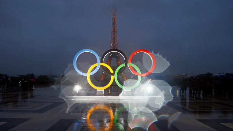 FILE - The Olympic rings are seen on the Place...