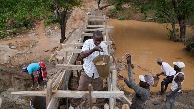 Residents in Machakos County, Kenya, construct a sand dam on...