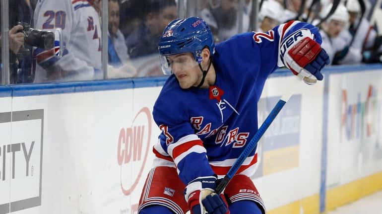 Adam Fox of the Rangers plays the puck during the...