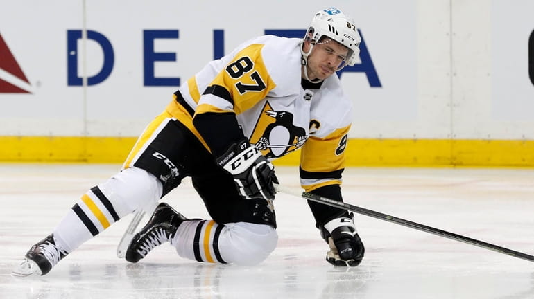 Sidney Crosby  of the Pittsburgh Penguins gets up slowly after...
