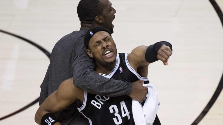 Paul Pierce (34) reacts with teammate Andray Blatche, right, after...