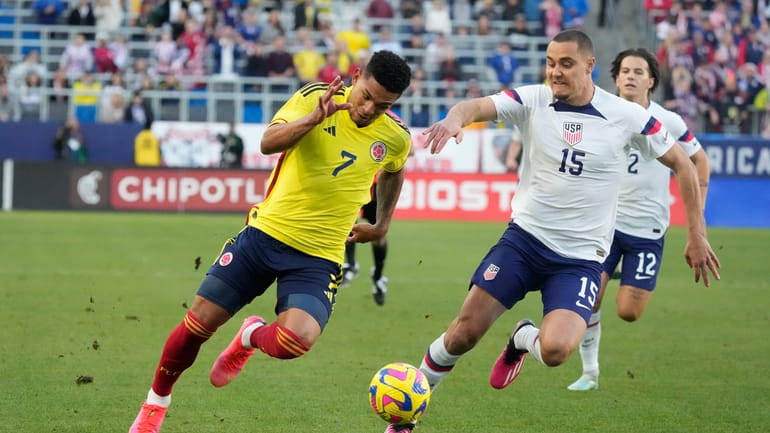 Colombia's Diego Valoyes, left, dribbles the ball past United States'...
