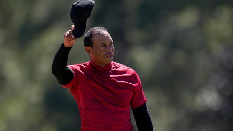 FILE - Tiger Woods tips his cap on the 18th...