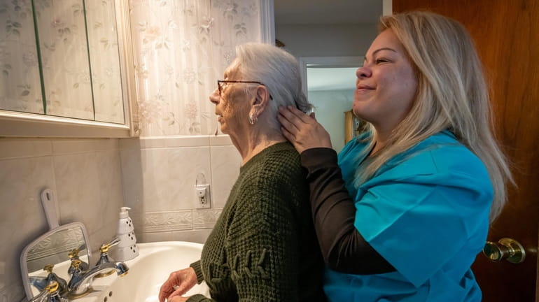Home care worker Mildred Garcia-Gallery, right, assists Christine Cipriani at Cipriani's home in...