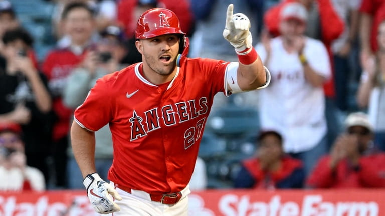 Los Angeles Angels' Mike Trout gestures as he scores on...