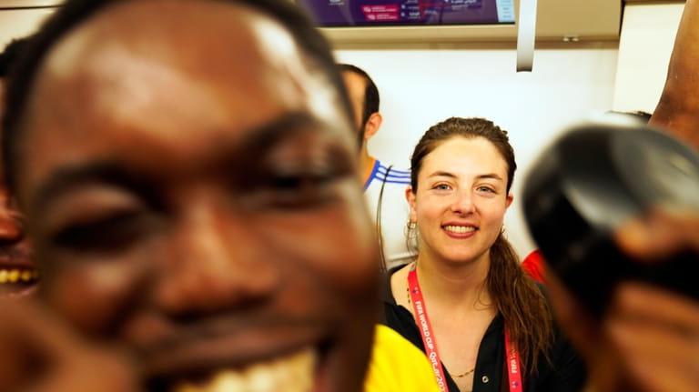 Associated Press correspondent Isabel DeBre, center, smiles as Ghana fans...