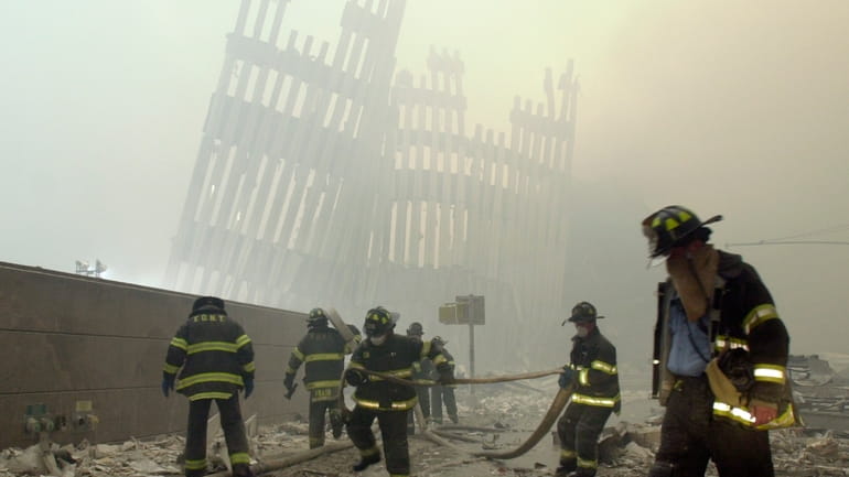 In this Sept. 11, 2001 file photo, firefighters work beneath...