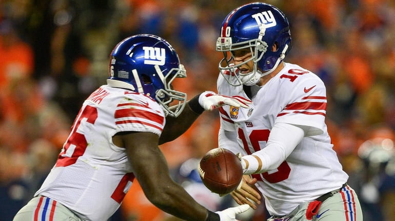 Giants quarterback Eli Manning hands off to Orleans Darkwa during...