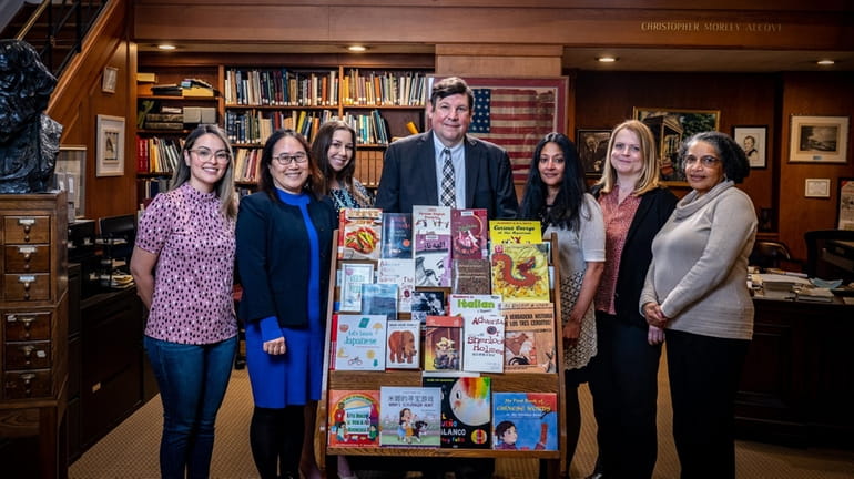 The Bryant Library director Victor Caputo, center, stands with his staff,...