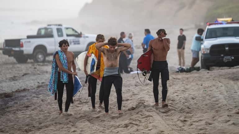 Surfers react to a drowning Tuesday at Ditch Plains Beach...