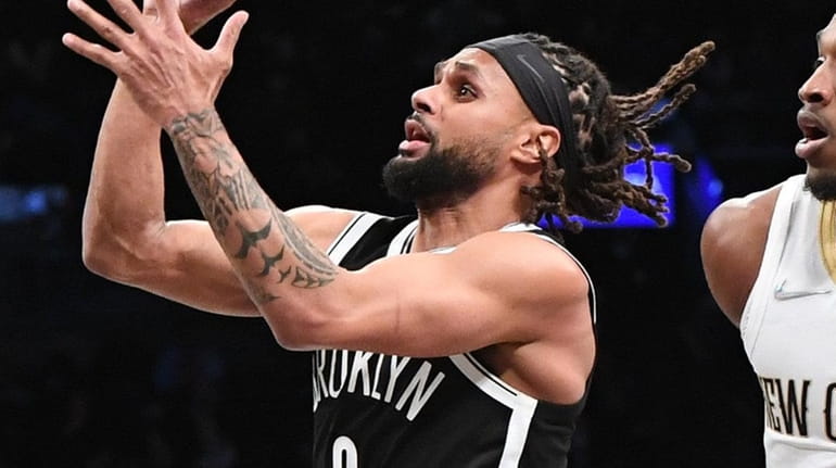 Nets guard Patty Mills puts up a shot against the...