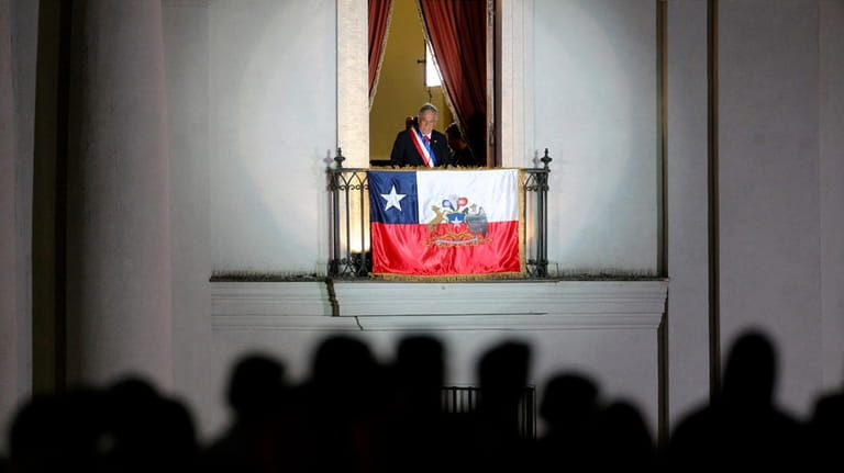 Chile's President Sebastian Pinera speaks to supporters from a balcony...