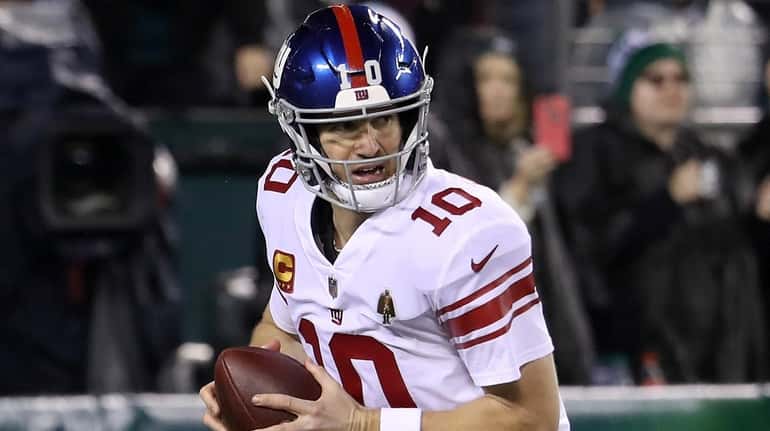 Giants quarterback Eli Manning drops back to pass against the...