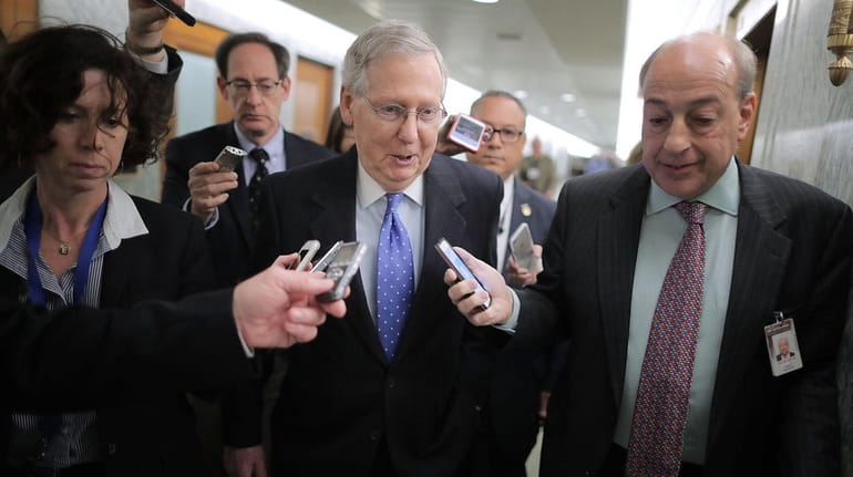 Senate Majority Leader Mitch McConnell talks with reporters after leaving...