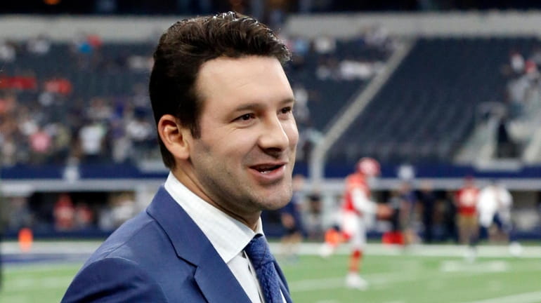 CBS football analyst Tony Romo walks across the field during...