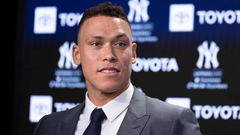 The Yankees' Aaron Judge looks on at his re-signing press...