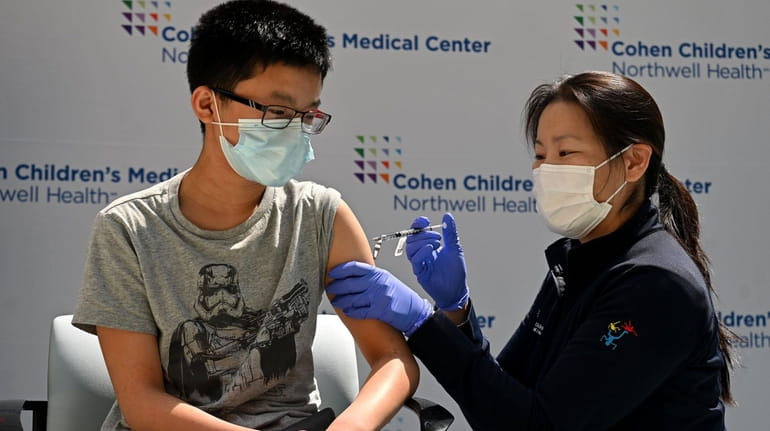 Brendan Lo, 13, of Great Neck, gets vaccinated at Cohen Children's...