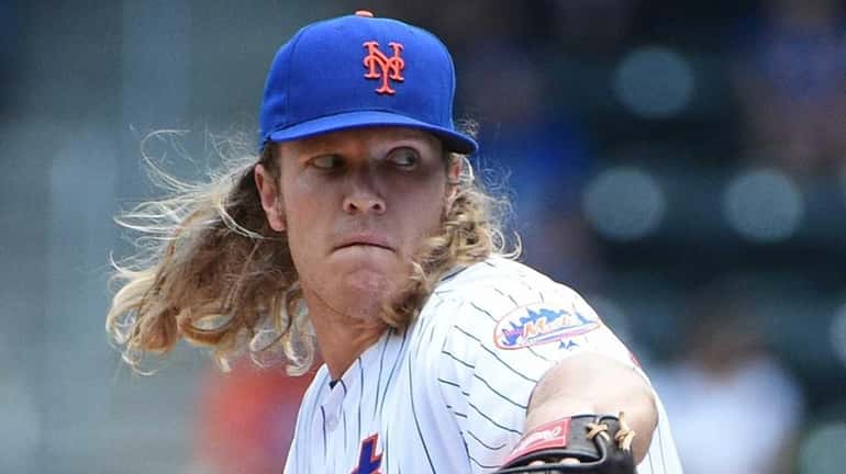 New York Mets starting pitcher Noah Syndergaard delivers a pitch...