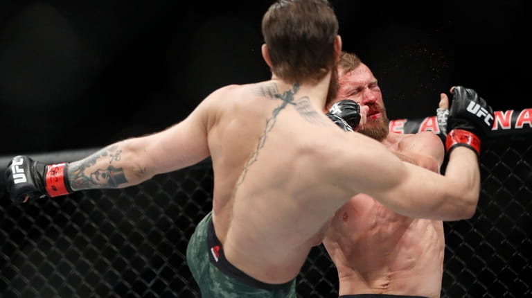 Conor McGregor kicks Donald "Cowboy" Cerrone during a UFC 246...