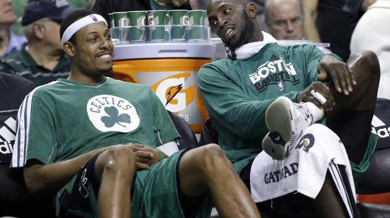 Kevin Garnett, right, chats with teammate Paul Pierce on the...