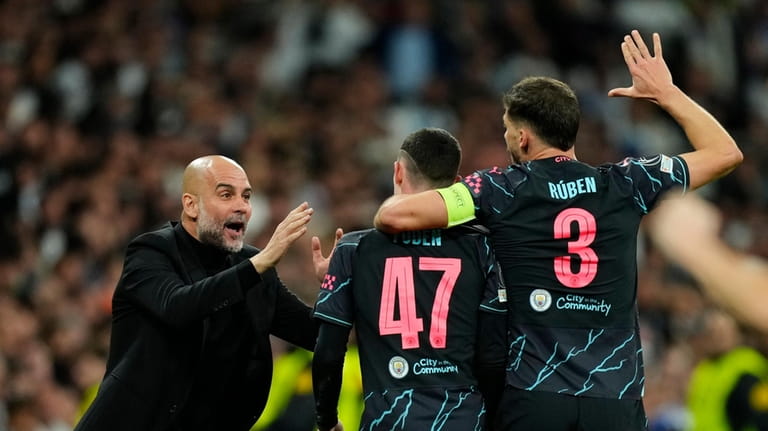 Manchester City's Phil Foden, center, celebrates with his Manchester City's...