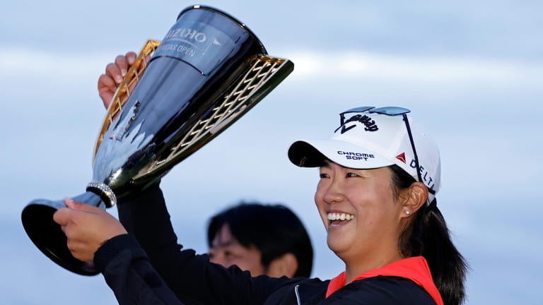 Rose Zhang holds up the trophy after winning the Mizuho...