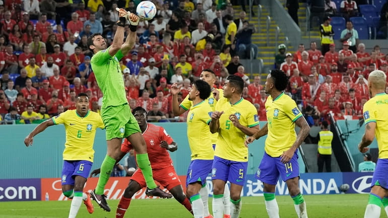 Brazil's goalkeeper Alisson, top, clears the ball during the World...