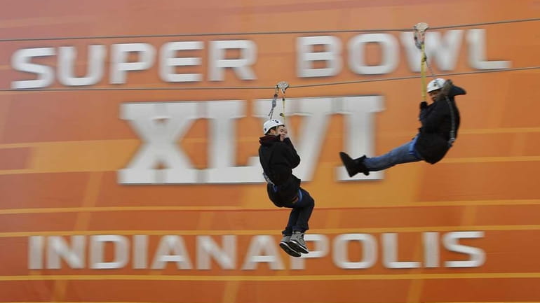 Fans ride a zip line during the NFL Experience. (Jan....