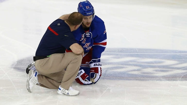 Derek Stepan is attended to by the trainer during the...