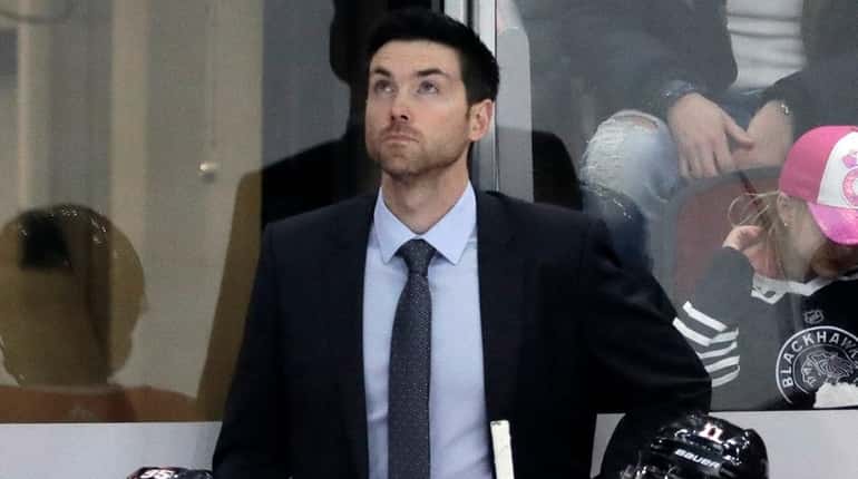 Blackhawks head coach Jeremy Colliton, top, and his players react...