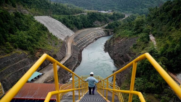 An employee walks down a stairway at Balambano hydroelectric plant,...