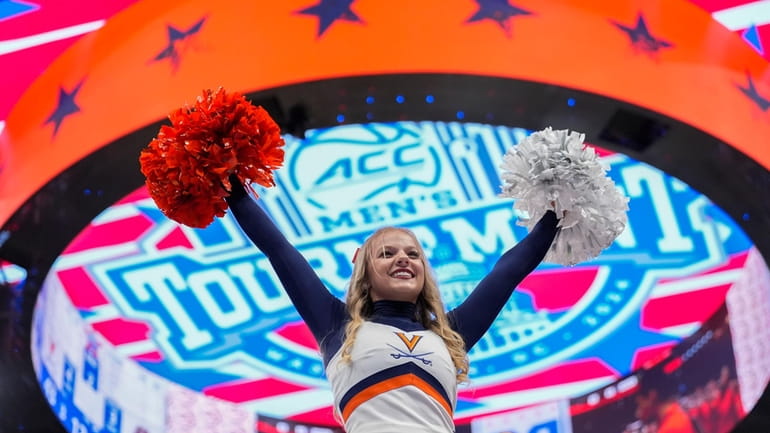 A cheerleader for Virginia is lifted upwards during the second...