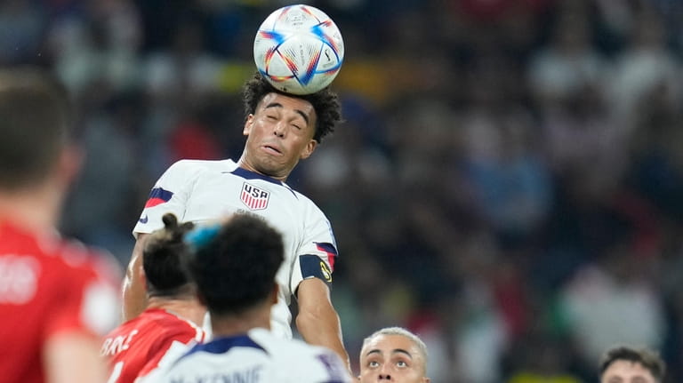 Tyler Adams of the United States heads the ball during...