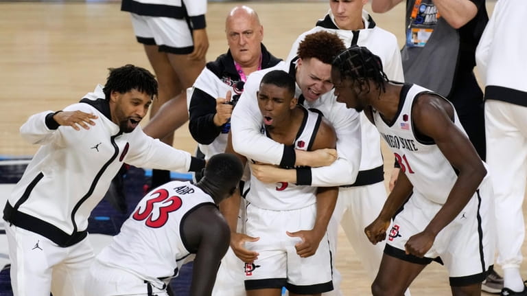 San Diego State guard Lamont Butler, center, celebrates with teammates...