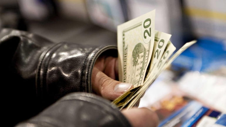 A holiday shopper counts his money as he prepares to...