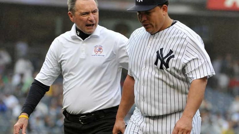 New York Yankees starting pitcher Bartolo Colon (40) is escorted...