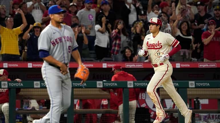 Los Angeles Angels' Shohei Ohtani, right, heads home after hitting...